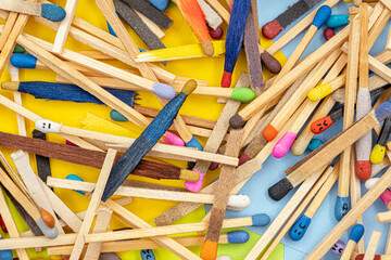 matchsticks of various shapes and colors with multicolored paper sticky notes on background