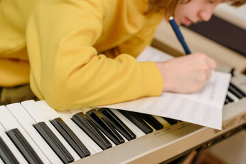 Closeup photo of young concentrated teen amateur songwriter writing song - obrazy, fototapety, plakaty