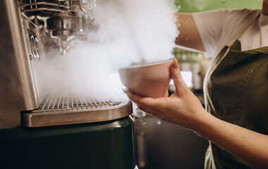 Coffee machine in steam, barista preparing coffee at cafe