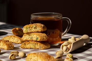 Biscotti Cantuccini Cookie Biscuits with pistachios and lemon peel Shortbread. Cup of tea. Teatime break Healthy eating food. Homemade fresh Italian cookies cantucci stacks and organic pistachios nuts