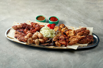 Assorted Grilled pork and chicken shish kebab in a plate with sauce and pita bread. Close-up.