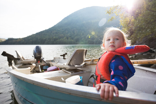 Girl sitting in motorboat with life jacket, Hicks Lake, Harrison Hot Springs, British Columbia, Canada