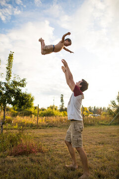 Father throwing son high into air, Langley, British Columbia, Canada