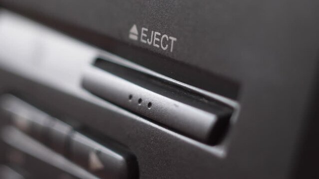 extreme close-up Pressing the button on the panel of the VCR with your finger ejects the video cassette. Videocassette player close eject buttons.Selective focus
