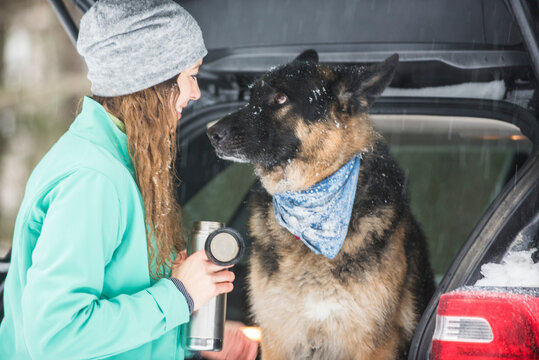 Woman and dog wrapping up snowy day in White Mountains