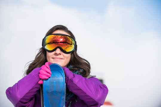 Woman with skis and ski goggles