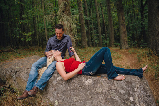 Portrait of blonde woman lying in man's lap in forest, Eugene, Oregon, USA