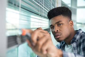 man working on blinds window