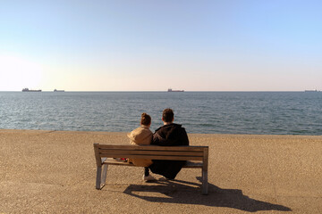 couple sitting on a bench by the sea