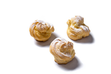Decorating profiteroles with powdered sugar. Eclairs with icing sugar