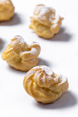 Decorating profiteroles with powdered sugar. Eclairs with icing sugar