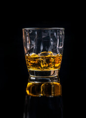 Whisky glass with ice on black background