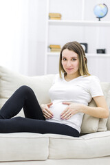 Young pregnant woman looking at the camera.