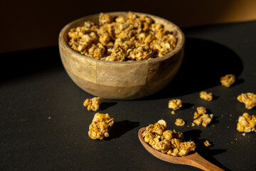 Homemade granola with nuts and seeds in eco tableware wooden bowl. Healthy snack on breakfast. Muesli from oatmeal, raisins, honey, cranberry, flax, almond, cashew, freshly baked