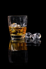 Whisky glass with ice on black background