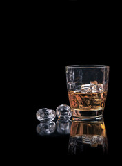 Whisky glass with ice on black background