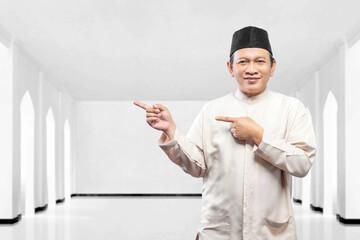Asian Muslim man pointing to something