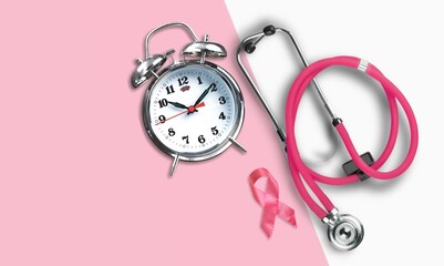 Breast cancer concept. Pink ribbon and retro clock with stethoscope