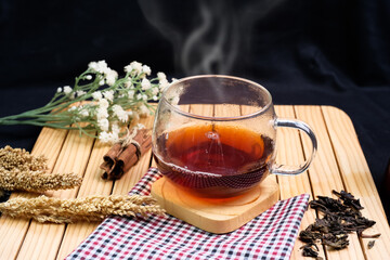 Herbal hot tea drink in glass with steam in festive composition on table