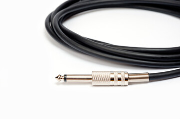 Long black jack cord for electric guitar, filmed on a white background.