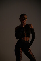 Fototapeta premium Stylish woman in a sexy black suit with lacing. Fashion photoshoot.