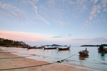 Fototapeta premium A view on a beach with longboats docked in the bay.