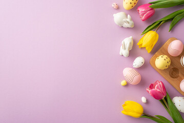 Fototapeta na wymiar Easter concept. Top view photo of colorful easter eggs in wooden holder ceramic bunnies yellow and pink tulips on isolated lilac background with blank space