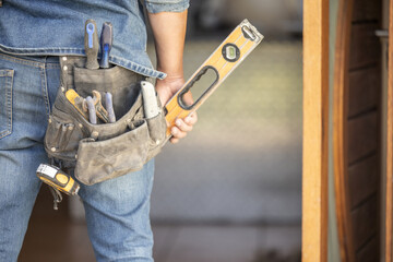 Maintenance man, bag and tools with hands, front door and home improvement service in property...