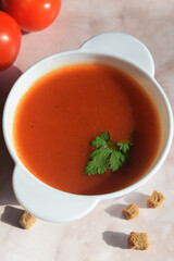vertical still life from a plate with tomato soup, tomatoes and breadcrumbs