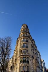 Fototapeta na wymiar Immeuble arrondi ancien. Paris. Ciel bleu.