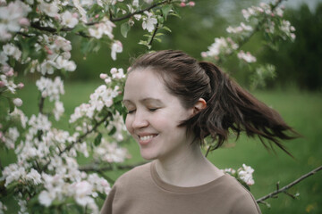Beautiful young woman near blooming spring tree. Youth, love, fashion, romantic and lifestyle concept