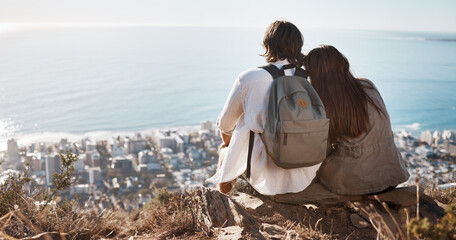 Couple, travel and cityscape with ocean view for peace and calm while hiking with a backpack. Man and woman together on vacation in nature with love, care and support with a hug outdoor on mountain