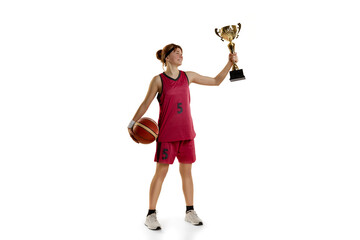 Winning game. Teen girl, basketball player posing with trophy, award isolated over white studio background. Concept of sportive lifestyle, active hobby, health, endurance, competition