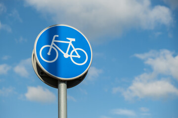 Round road sign depicting white bicycle on blue background, meaning mandatory bike path for...