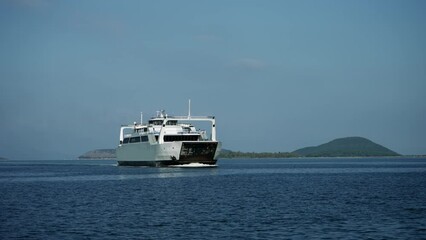 Cinematic shot of ferry boat sailing on sea line from mainland to island in Greece