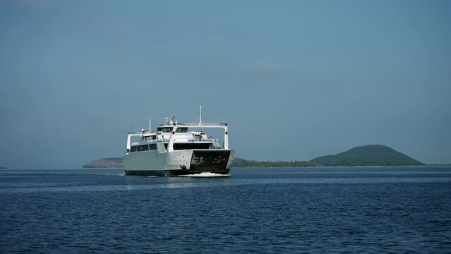 Cinematic shot of ferry boat sailing on sea line from mainland to island in Greece