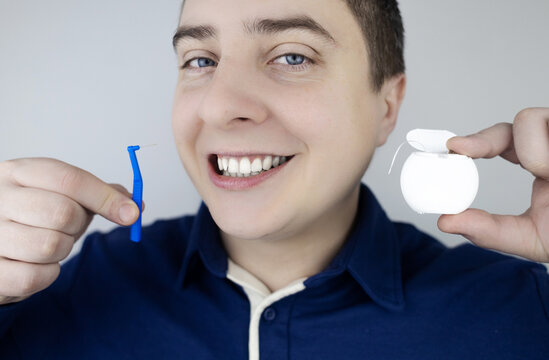 Interdental brush. A man shows a brush for cleaning the interdental space. Brush for cleaning teeth and daily oral care. Dentistry and orthodontics 