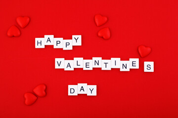 inscription Valentine's day and red hearts on a red background