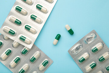 Medical blister packs with pills on blue background