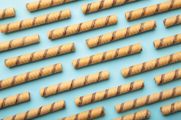 Wafer roll sticks cream rolls on blue background. Minimalism