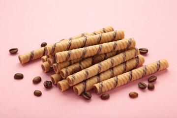 Coffee wafer stick roll with coffee cream on pink background