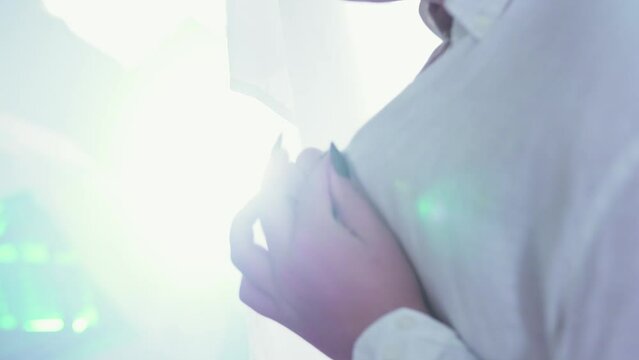 Cinematic shot of a LGBT man unbuttoning his shirt in the sunshine