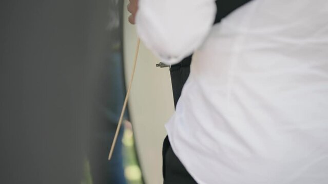 Man drumming on celebration wedding ceremony, playing traditional songs with a drum, cinematic selective focus slow motion shot