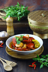 Kepiting Saos Padang or Indonesian Spicy crabs, served with shrimp and corn. Selective focus on dark wooden background.
