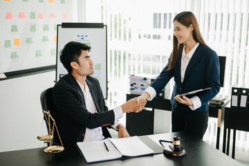 Judge and client shaking hands and lawyers discussing contract papers  after adviced in background at courtroom, lawyer service concept.