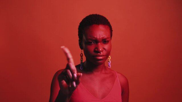 No gesture. Bad idea. Refusal disagreement. Red neon color light criticizing dissatisfied skeptic woman warning with finger wag isolated on dark bright gif loop boomerang animation.