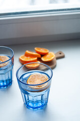 A refreshing blue glass beverage with an orange slice for decoration. Perfect for summer or a party, or for any occasion that needs a pop of color and flavor