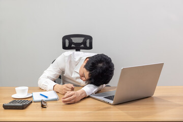 Man with narcolepsy is fall asleep on office desk..Narcolepsy is a sleep disorder that makes people very drowsy during the day. - obrazy, fototapety, plakaty