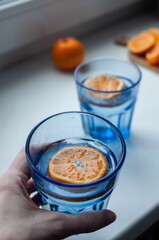 A refreshing blue glass beverage with an orange slice for decoration. Perfect for summer or a party, or for any occasion that needs a pop of color and flavor