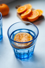 A refreshing blue glass beverage with an orange slice for decoration. Perfect for summer or a party, or for any occasion that needs a pop of color and flavor